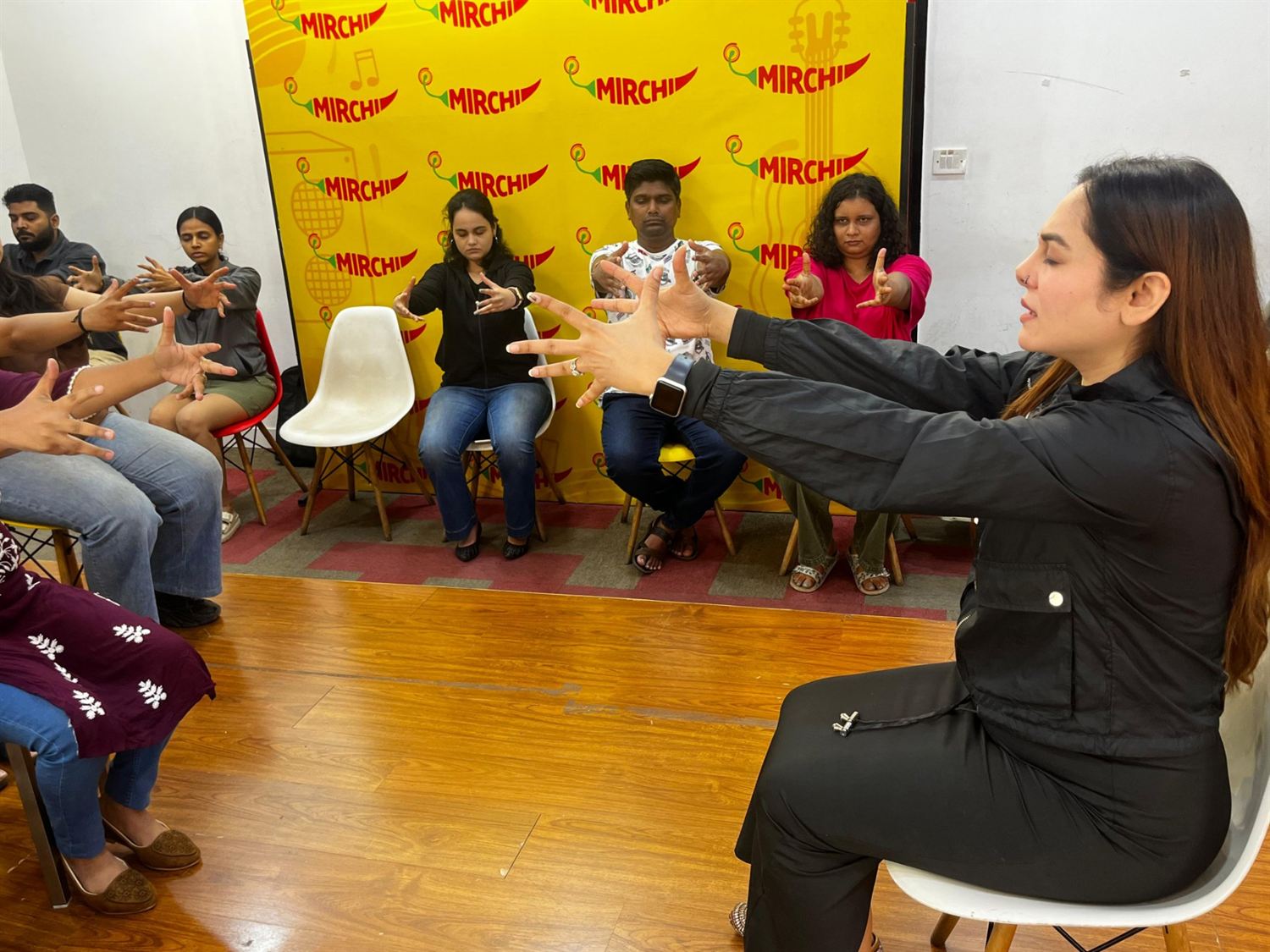 Vibha Jain conducting a group hypnotherapy demonstration with a seated audience participating