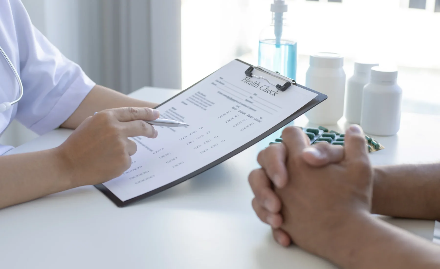 A health professional reviewing a written checklist with a client, representing structured review of habits and goals